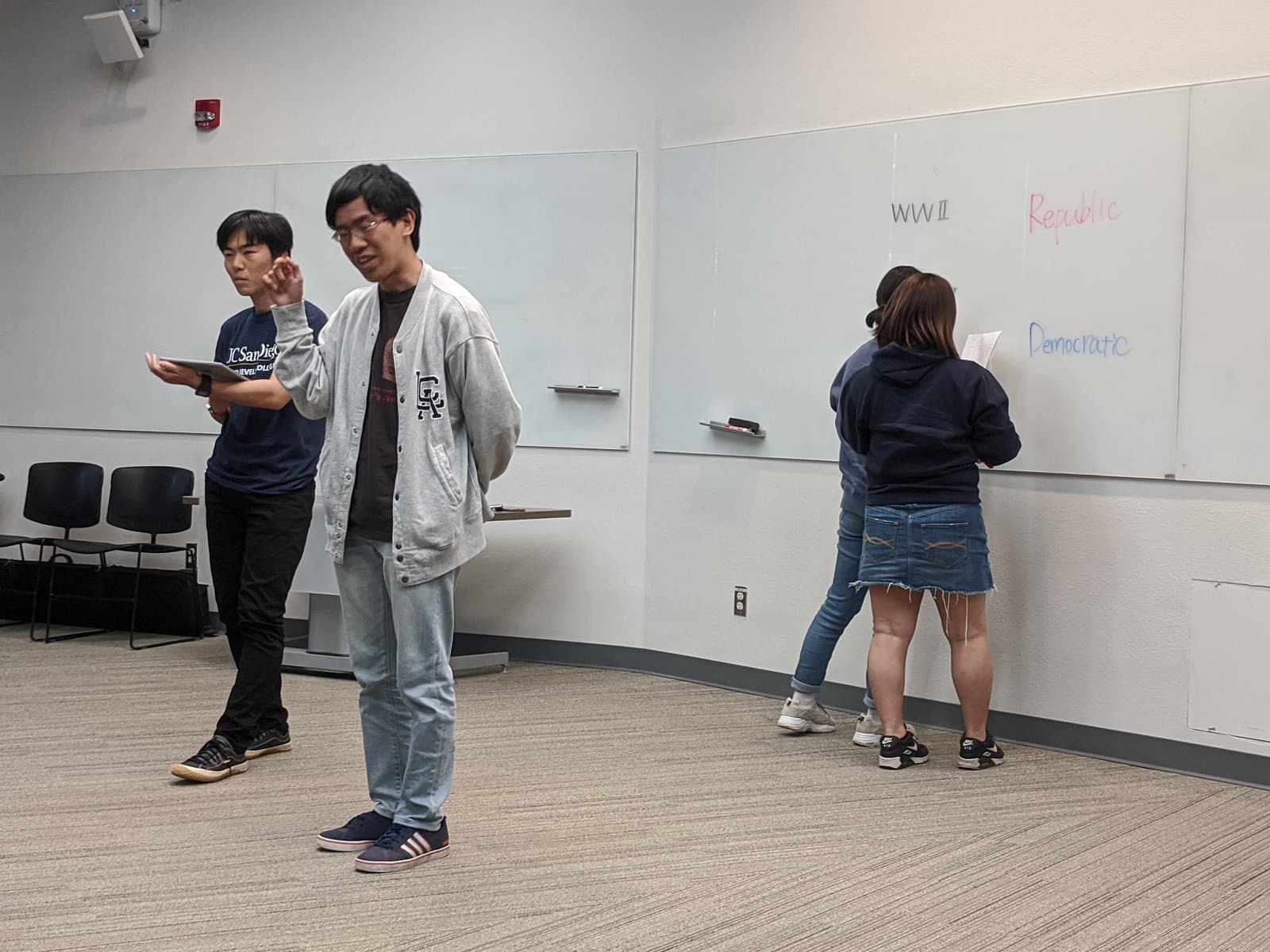 在教室白板前發表的參加學生。白板上以英語寫著講座的關鍵字。